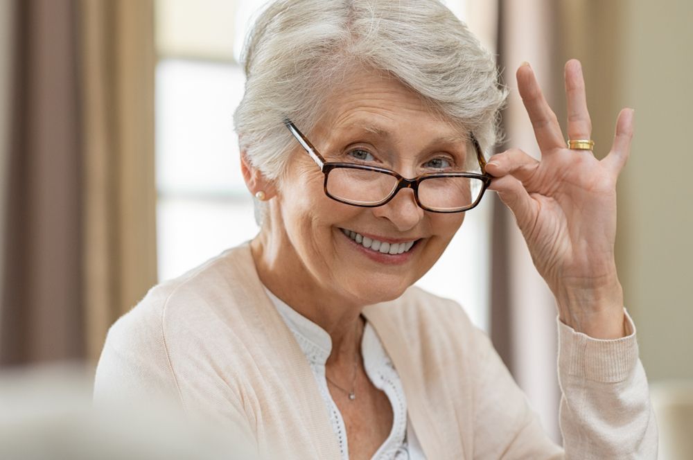 An Elderly Woman Wearing Glasses Is Smiling — John Williams Optometrist in Grafton, NSW