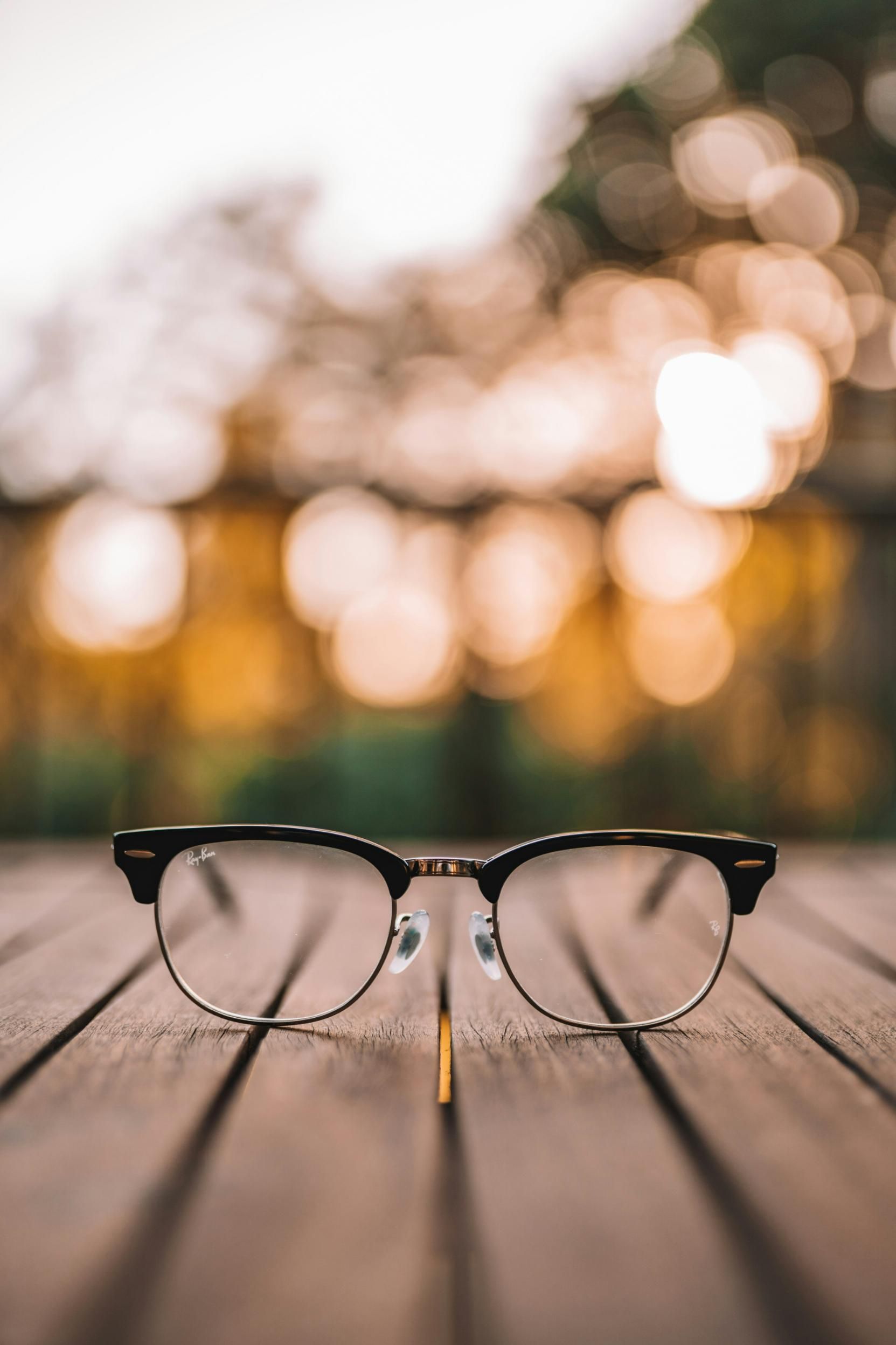 A Pair of Glasses Is Sitting on A Wooden Table — John Williams Optometrist in Grafton, NSW