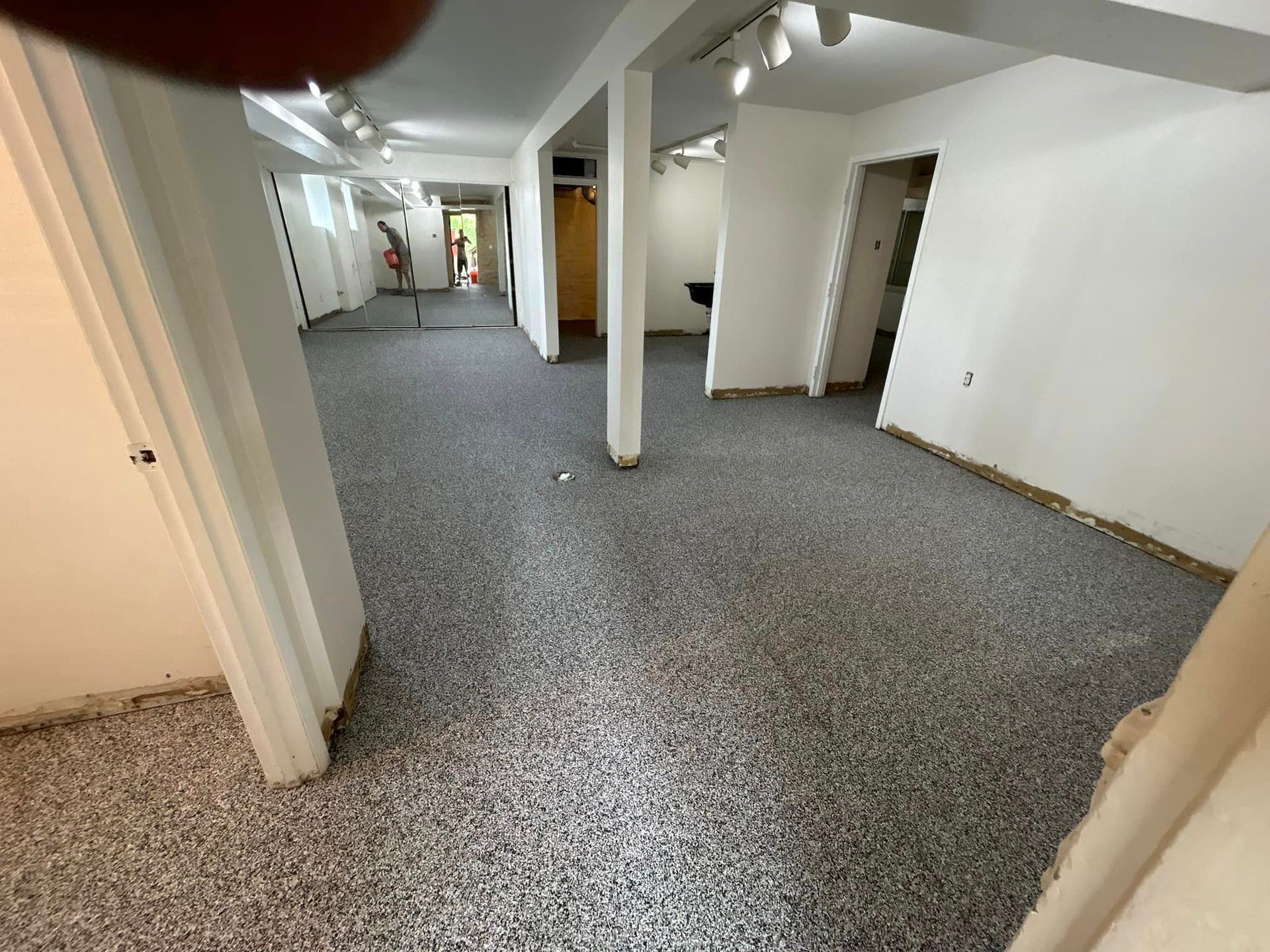 A large empty room with a gray floor and white walls.