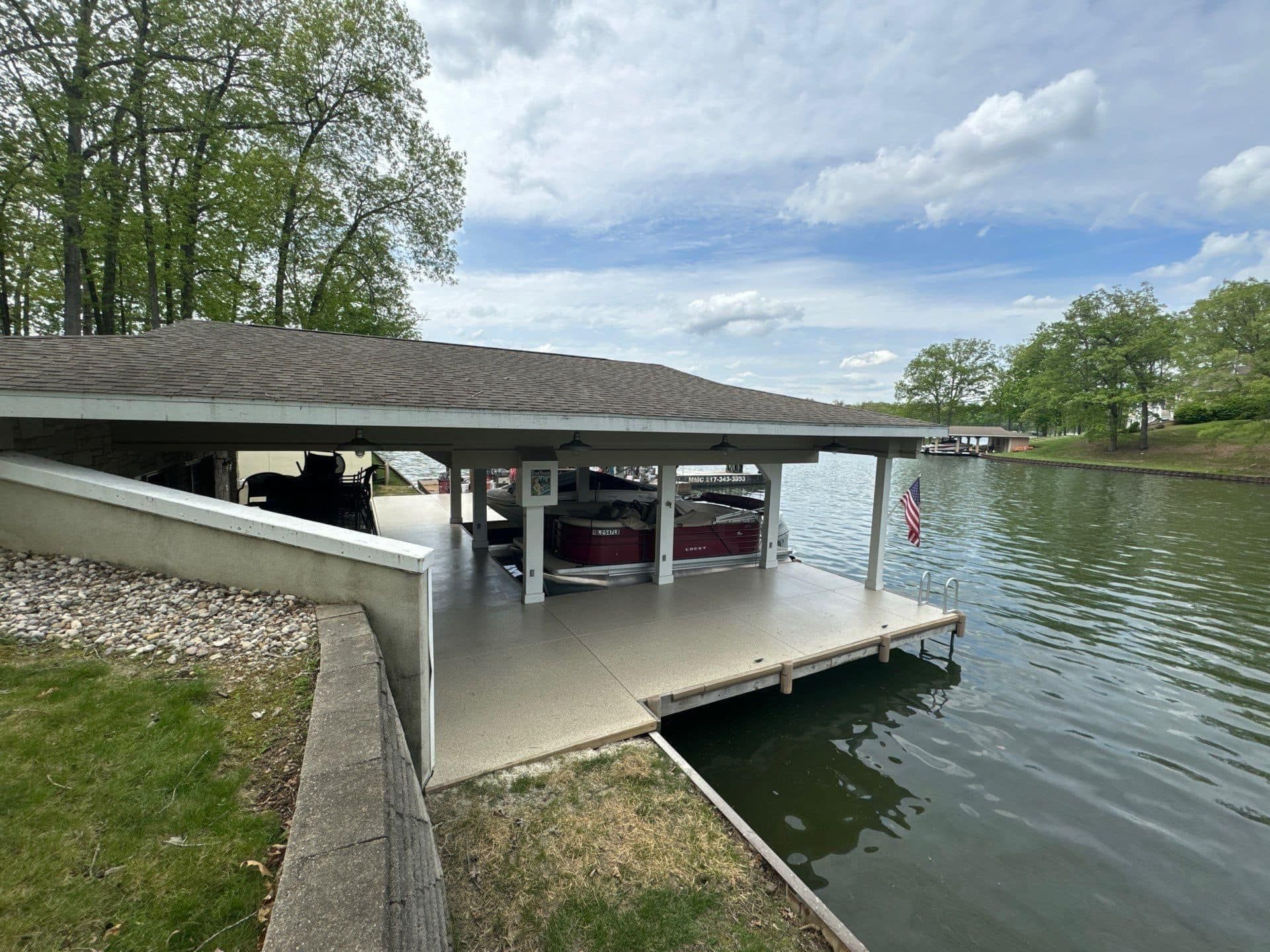 A boat is under a covered dock next to a body of water.