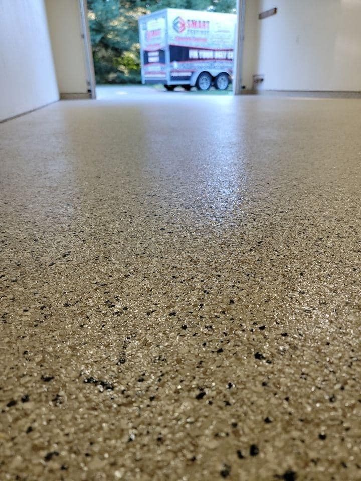 A garage floor with a truck parked in the background.