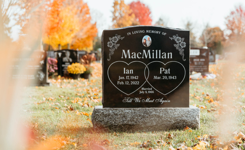 A gravestone in a cemetery with a heart on it.