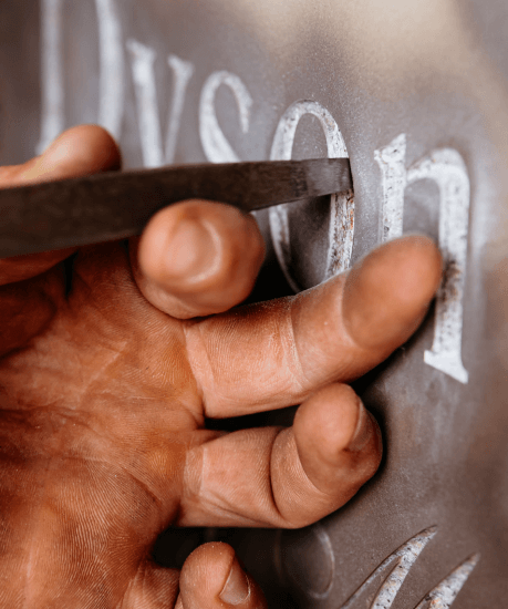 A close up of a person 's hand carving the word jason