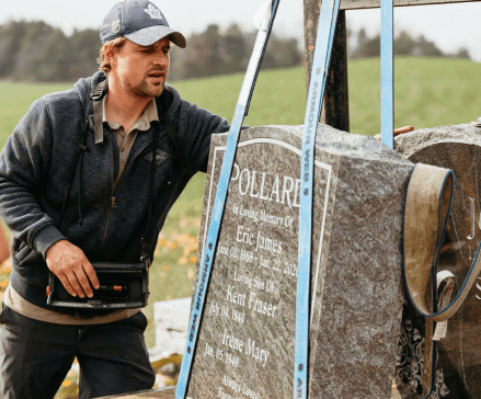 A man is standing next to a gravestone that says pollare on it.