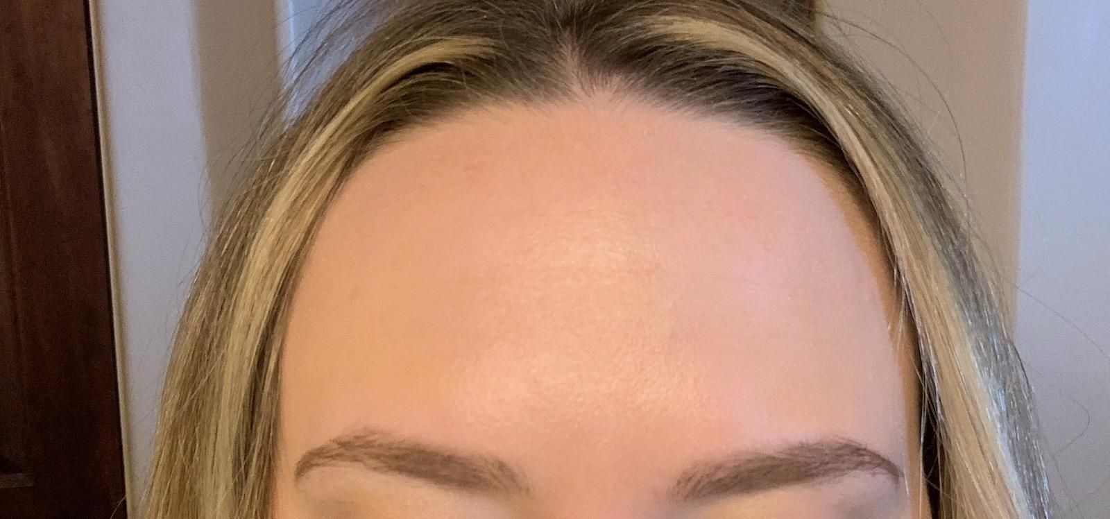 Close-up of a person's forehead, eyes, and eyebrows with blonde hair framing the face.