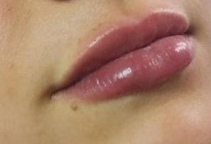 Close-up of full, glossy lips with a hint of pink, slightly parted.