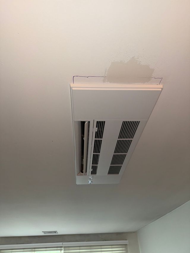 White ceiling with a rectangular air vent; a water stain is visible above it.