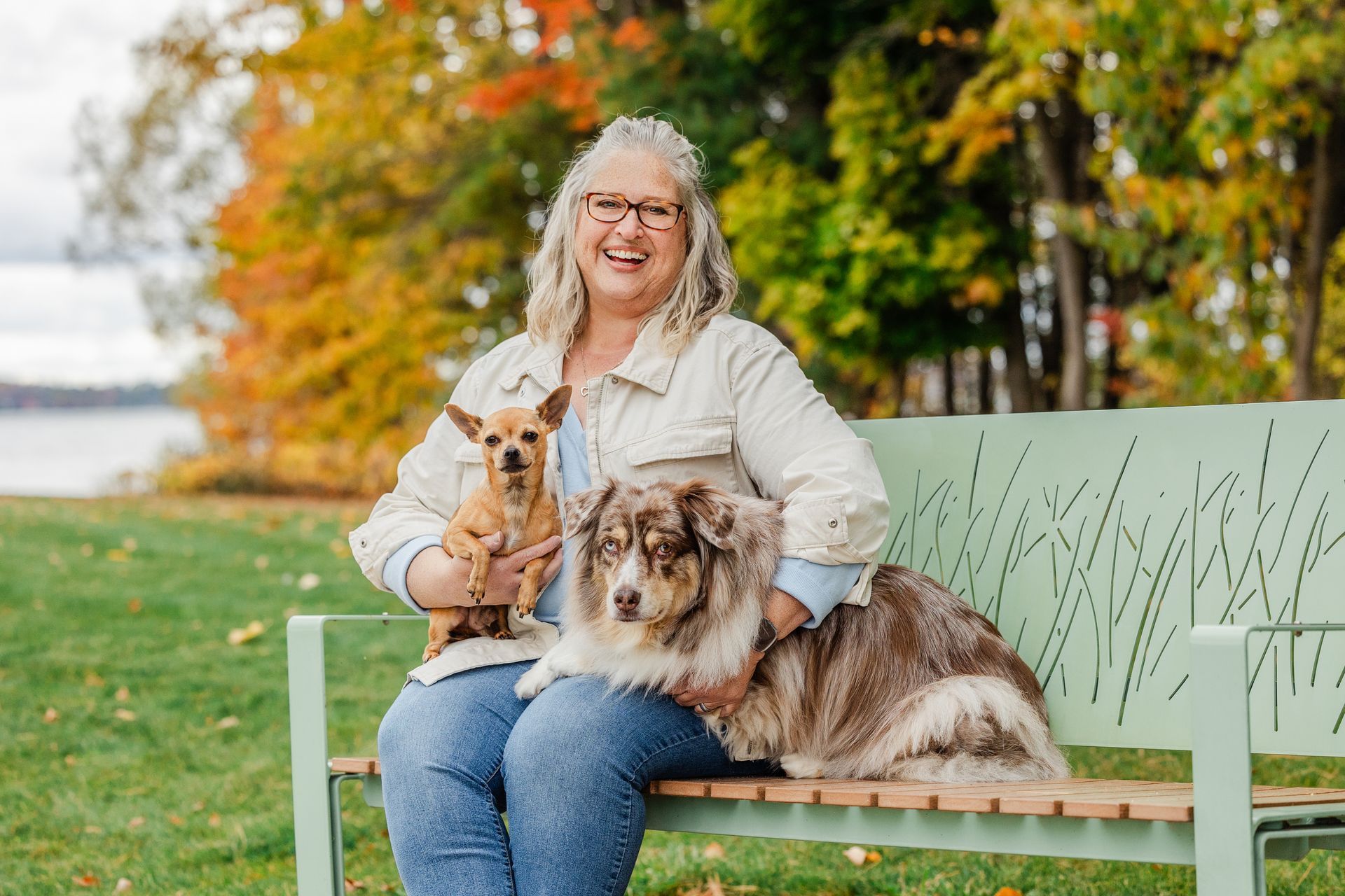 Professional Dog Trainer, Meghan Rosenstengel sitting on a bench with her two dog.