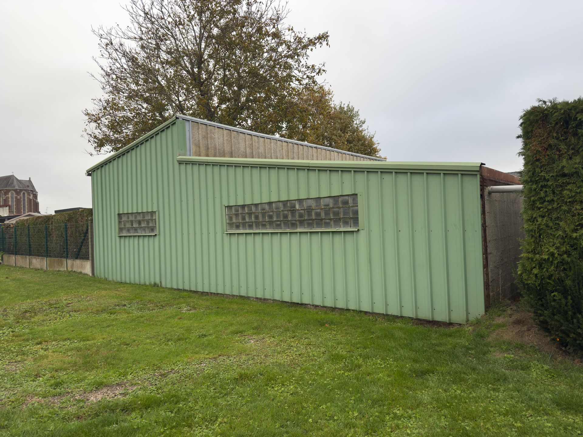 A green utility shed is on a grassy lawn. A green utility shed is on a grassy lawn.