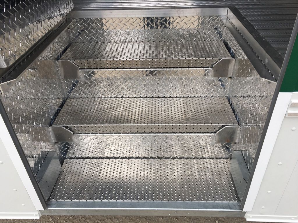 A stainless steel staircase leading up to a green wall