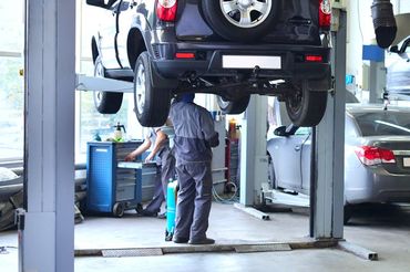A car is being lifted on a lift in a garage.