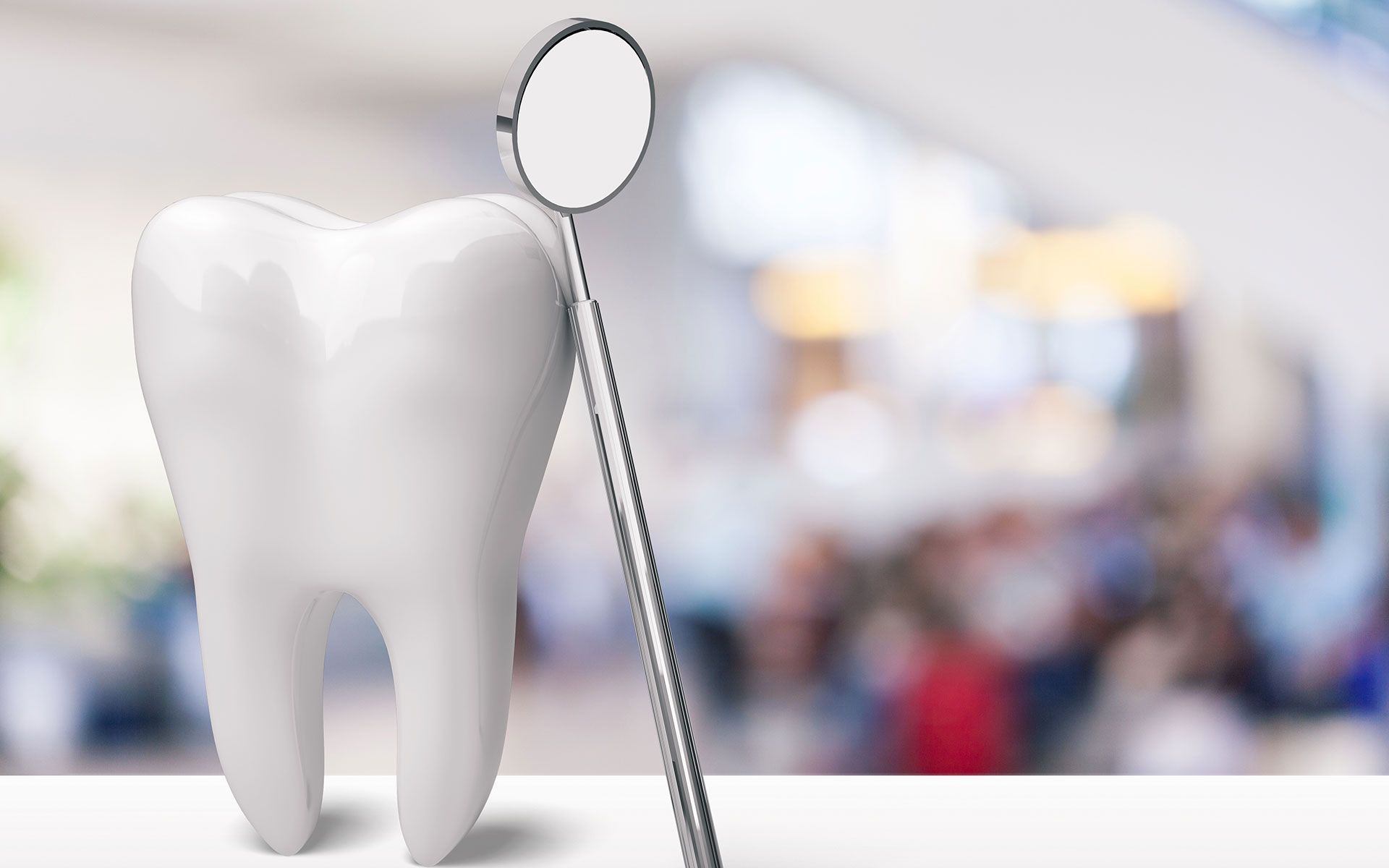 A tooth and a dental mirror on a table.