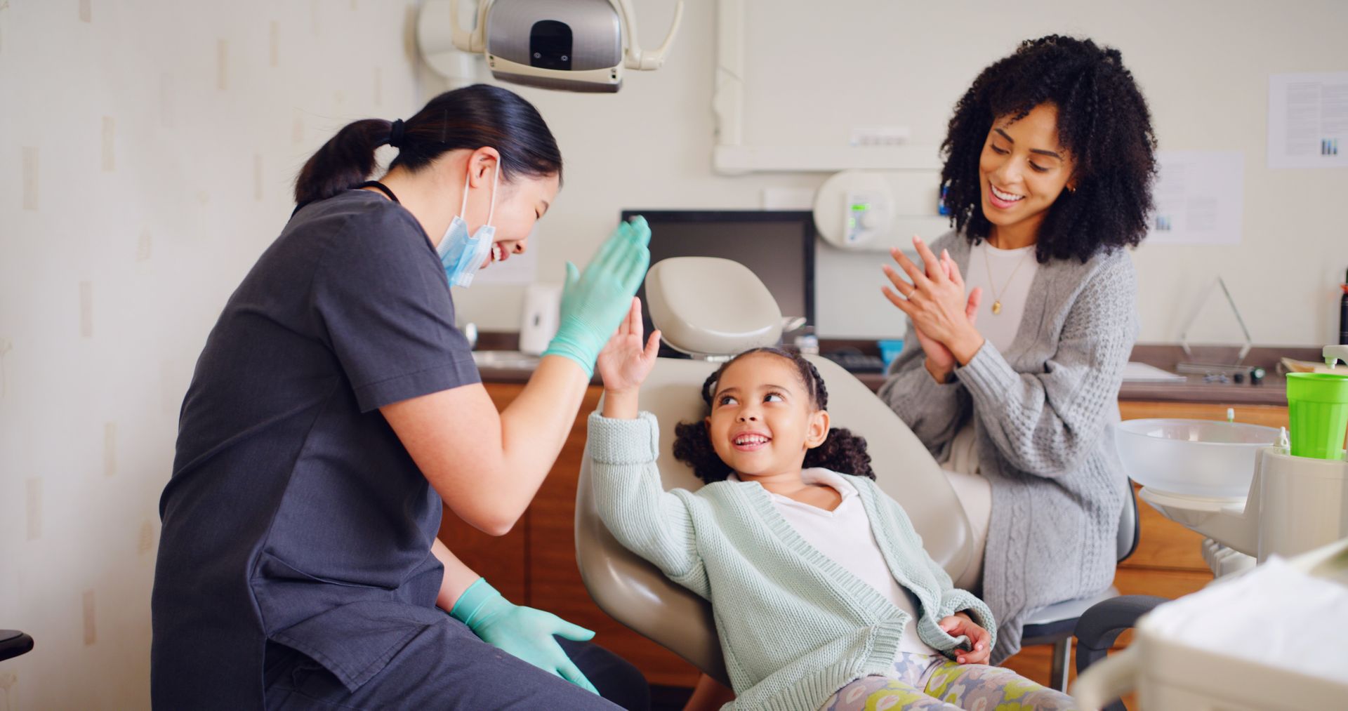 A dentist is giving a high-five to a kid.