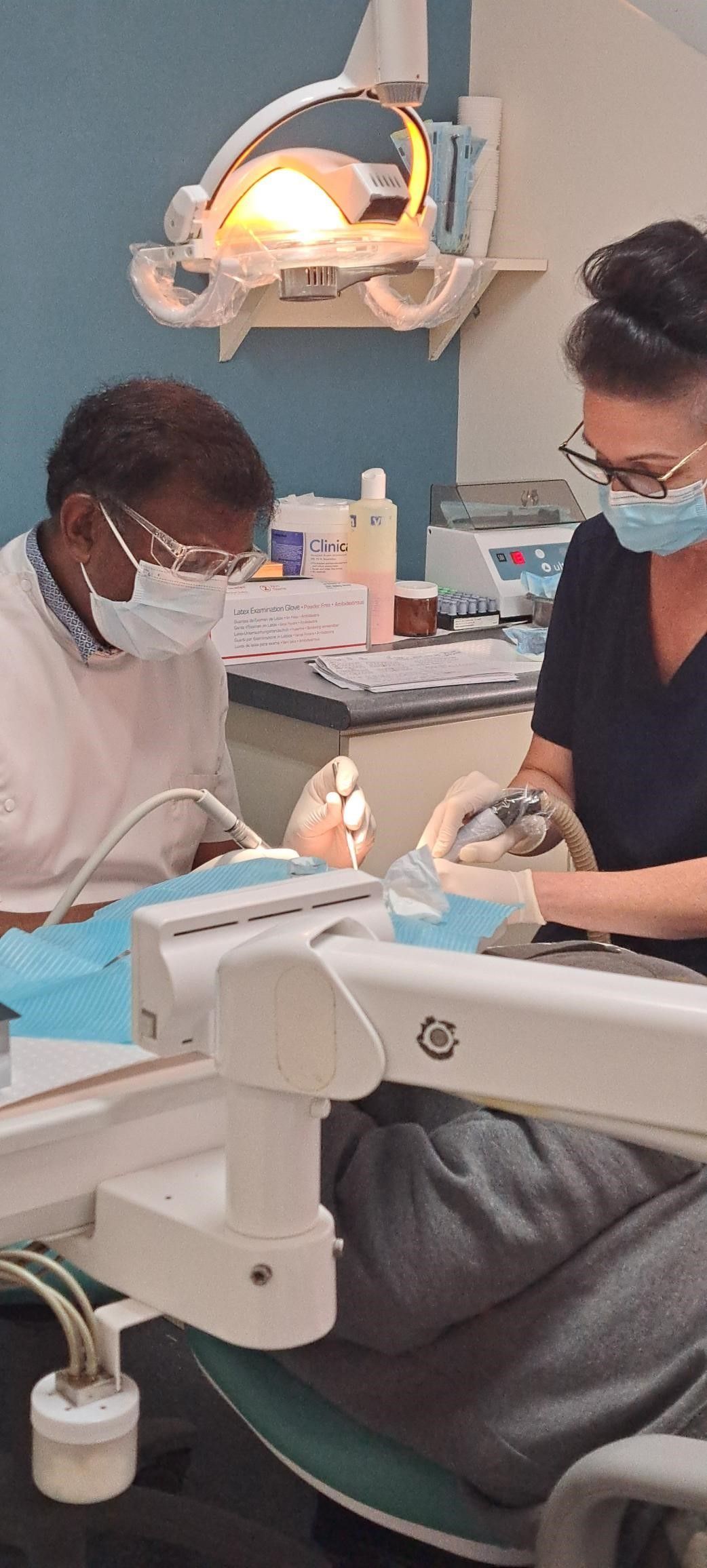 A dentist is giving a little girl a high five in a dental office.
