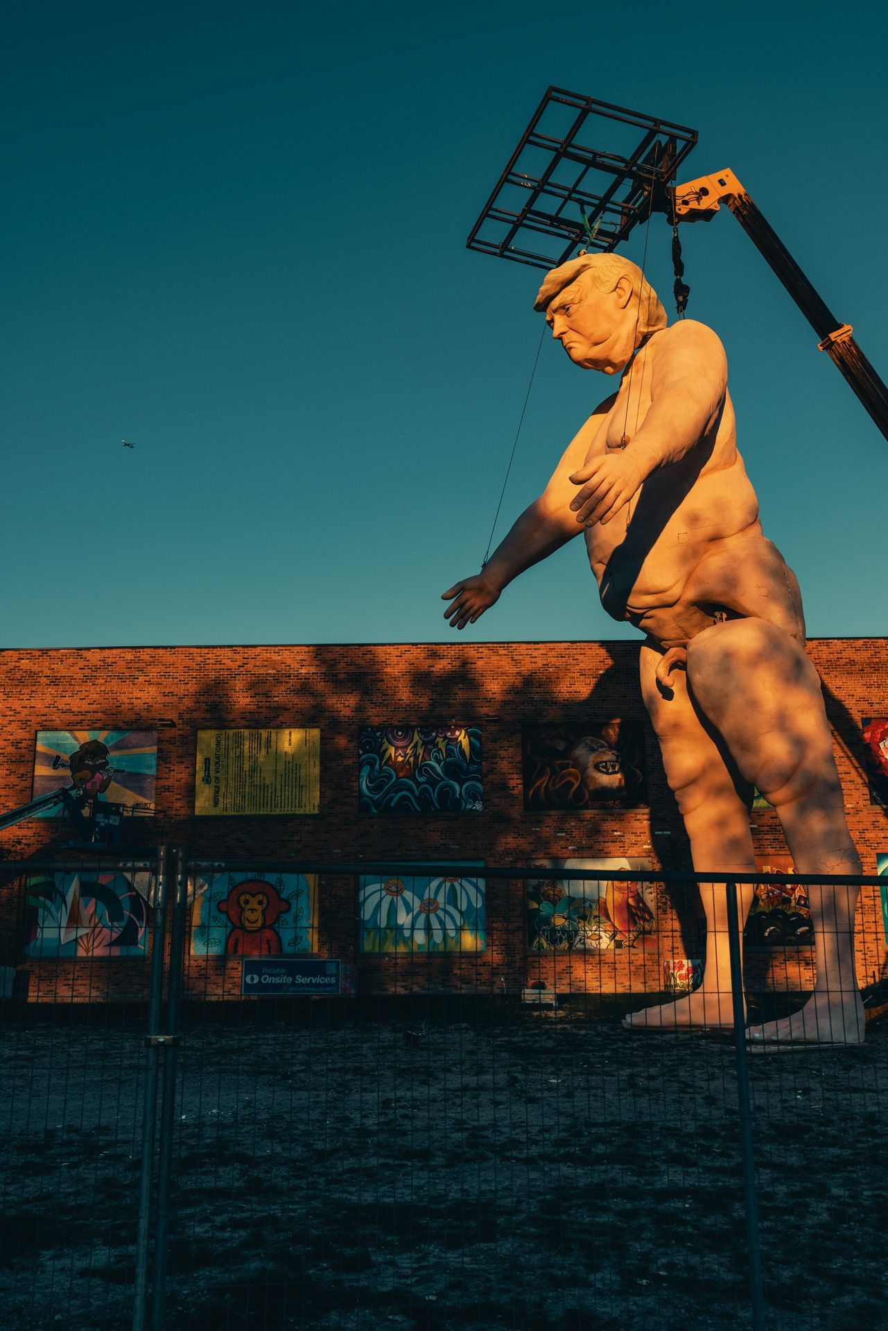 Image of a 43-foot tall sculpture of failed president Donald Trump depicted as a marionette, taken at sunset in Detroit