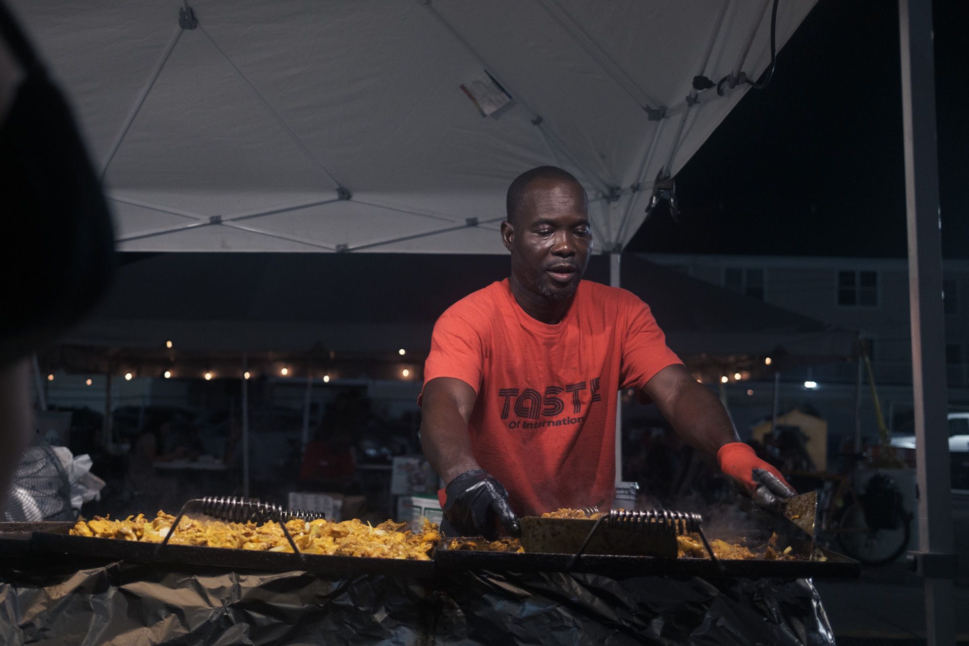 man cooking food at the taste of international booth at Hamtramck Labor Day festival