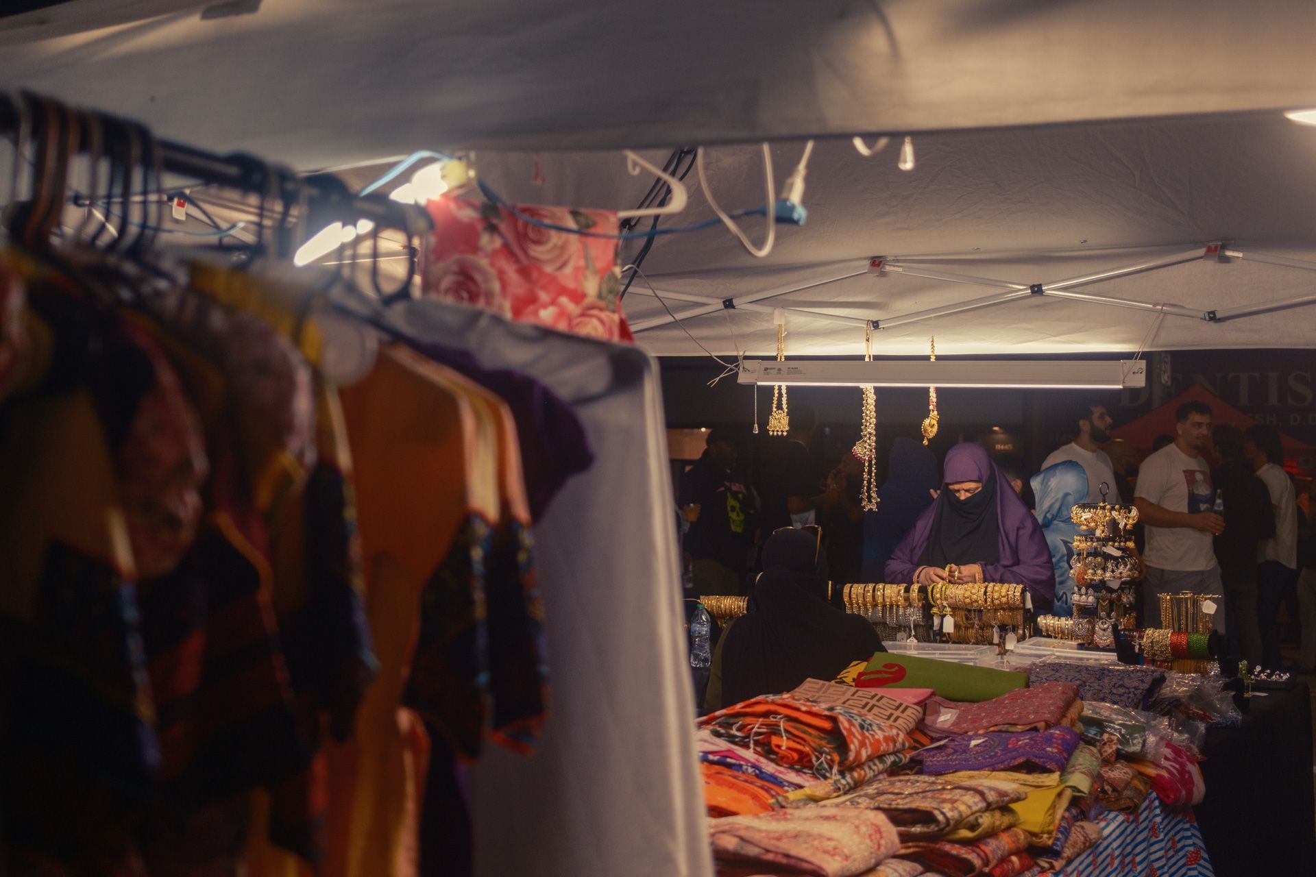 Woman browsing gold jewlery at a nighttime street festival in Detroit, Michigan.