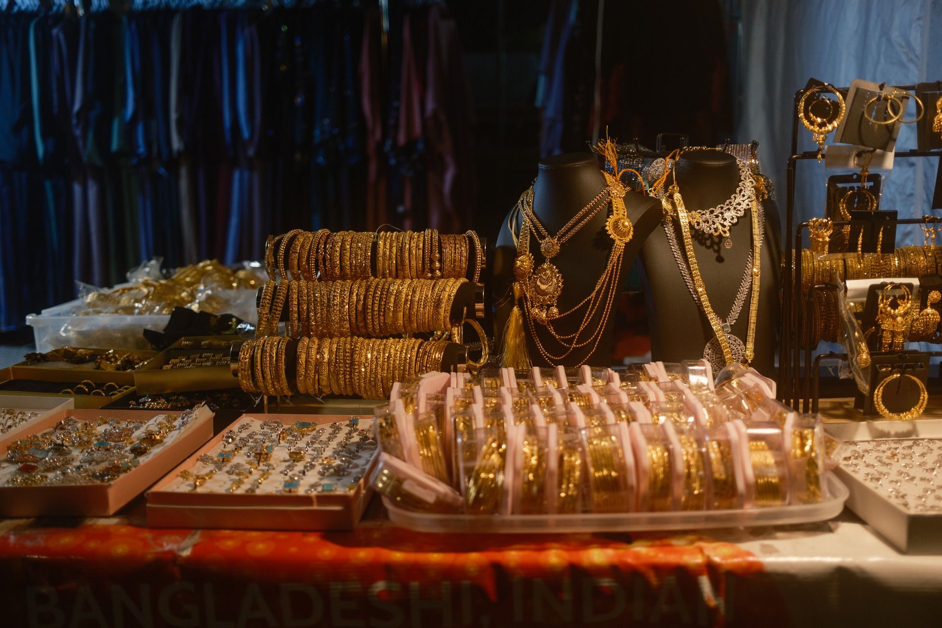 a vendor table piled with gold jewelry for sale during a street festival in Hamtramck, MI