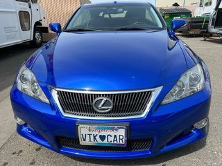 A blue lexus is parked in a parking lot with a california license plate.