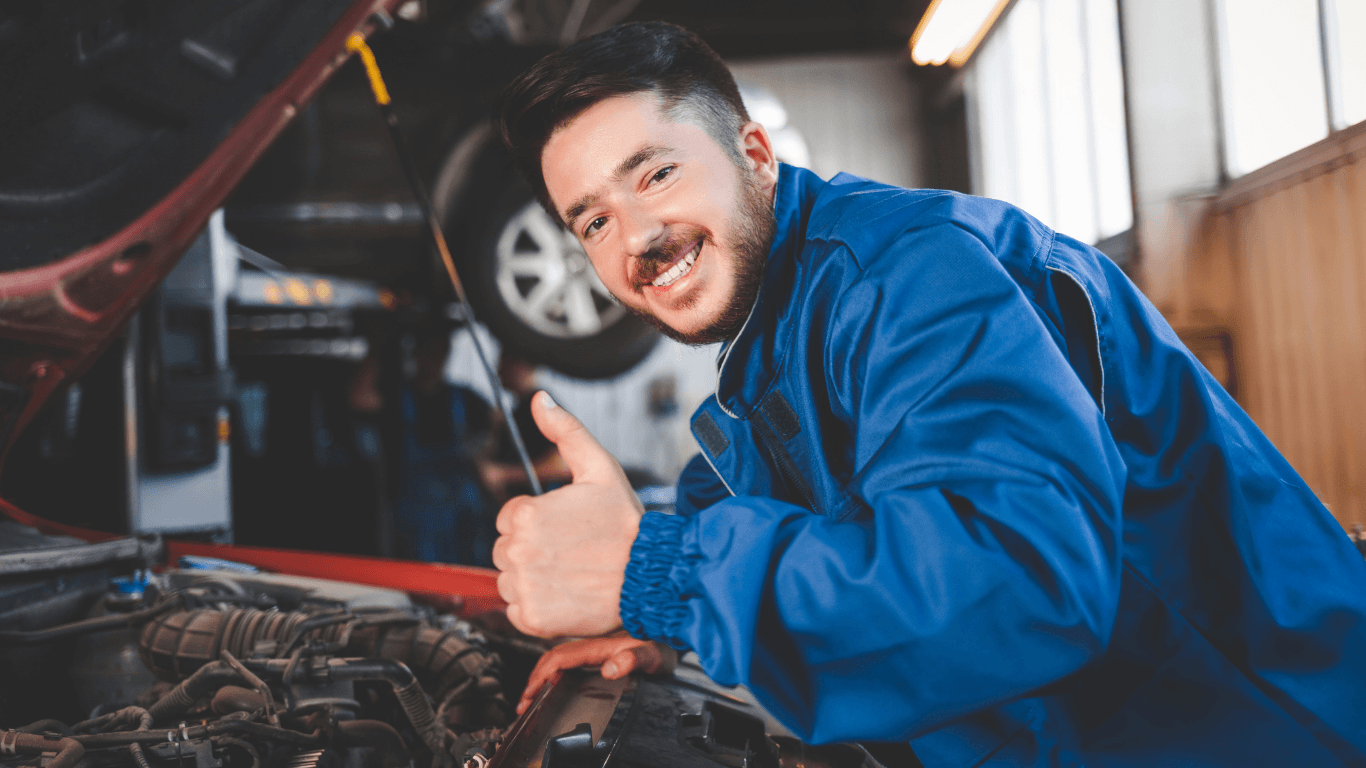a mechanic smiling and giving a thumbs up