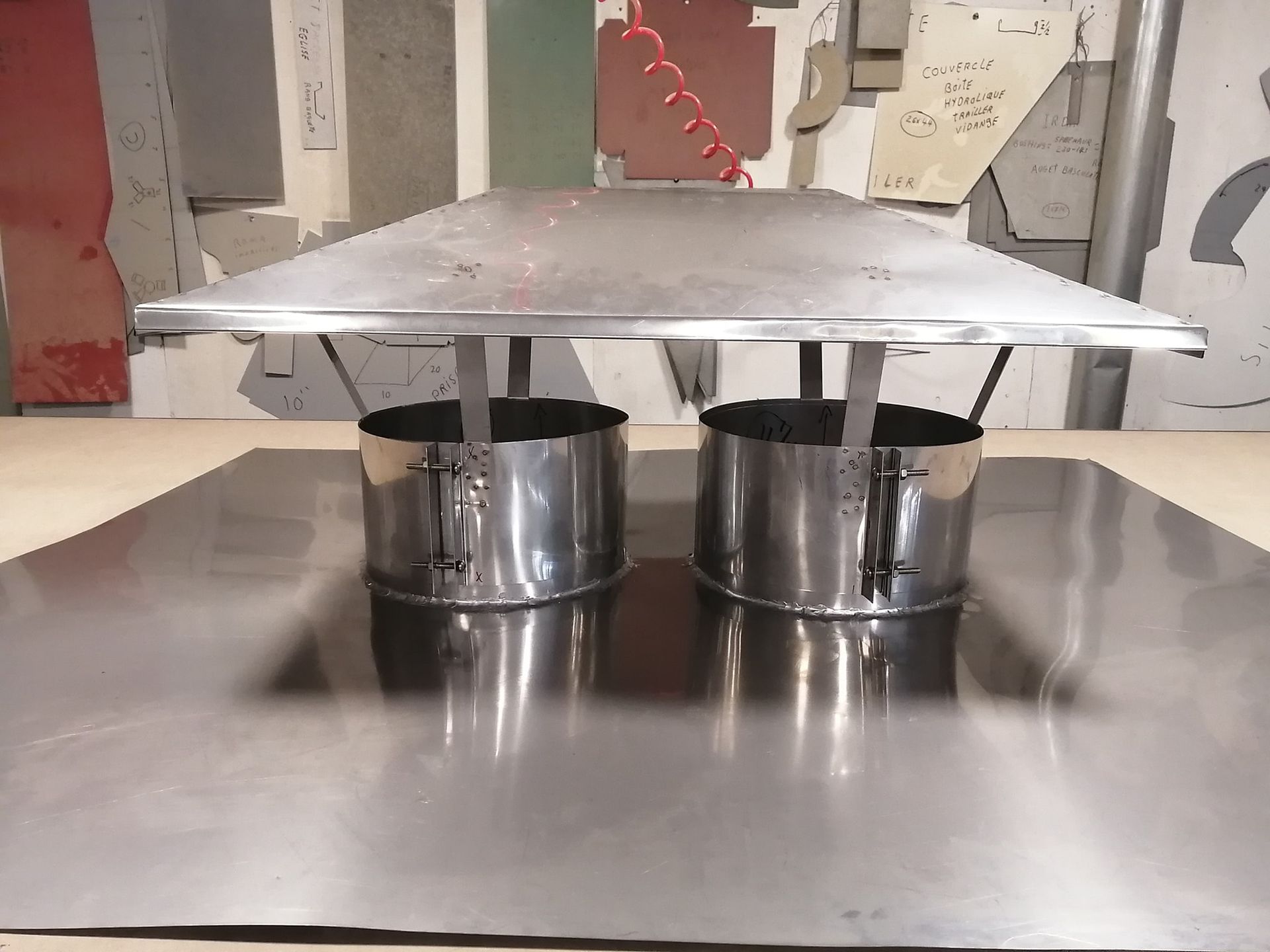 Un chapeau de cheminée en acier inoxydable est posé sur une table