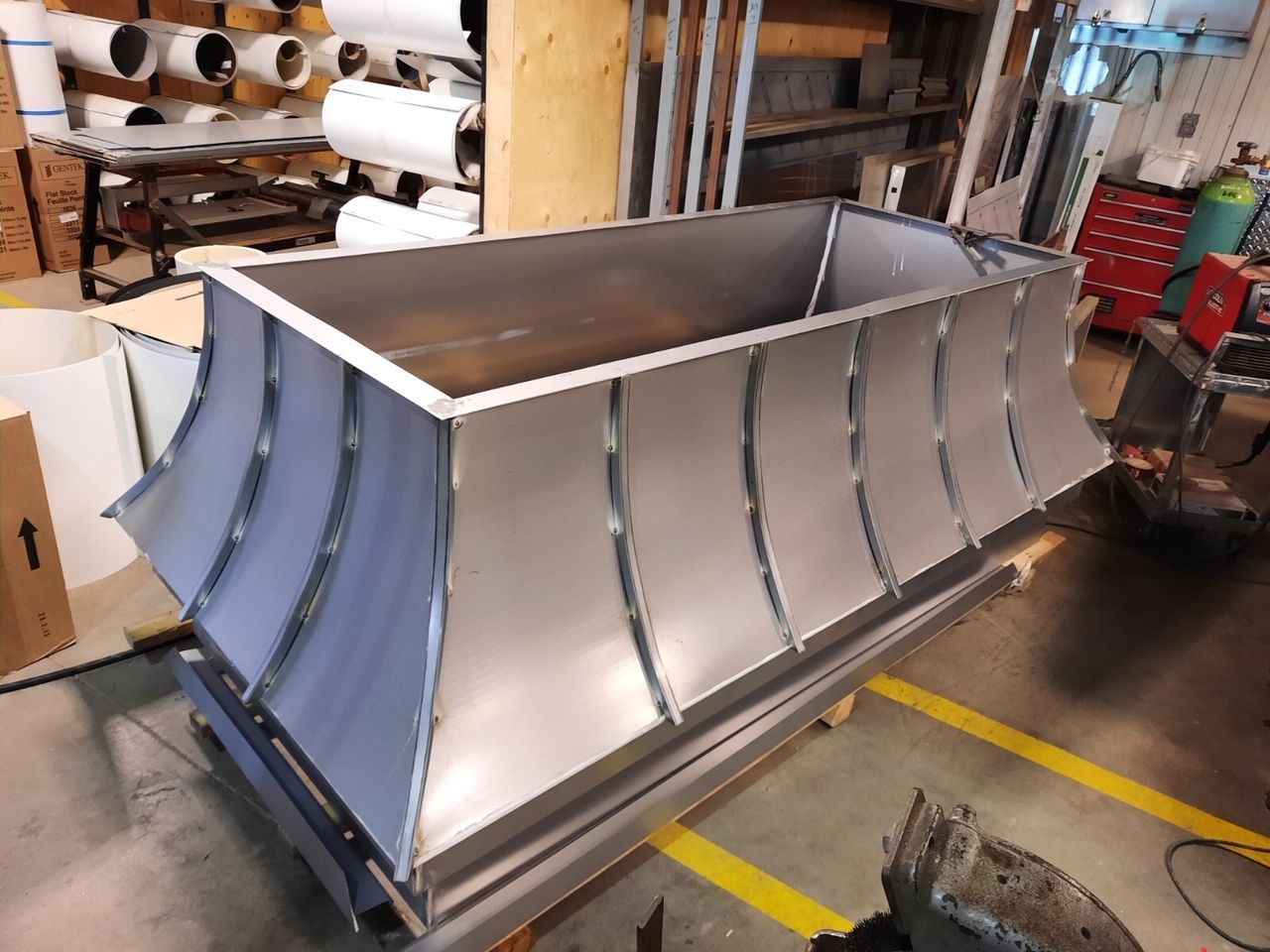 Un grand récipient en métal est posé sur une table dans une usine.