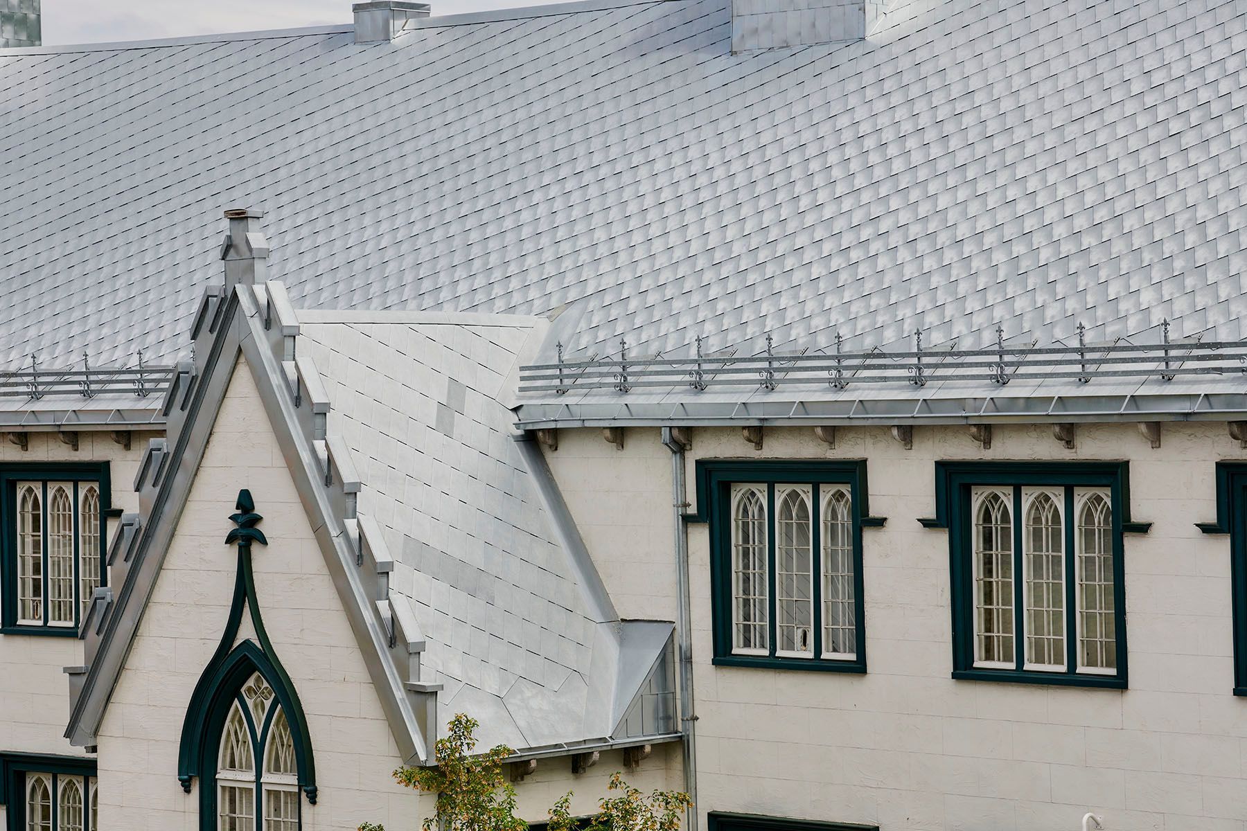 Un bâtiment blanc avec des fenêtres vertes et un toit blanc