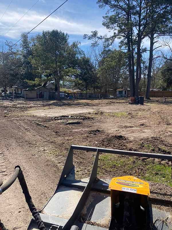 A tractor is sitting in the middle of a dirt field.