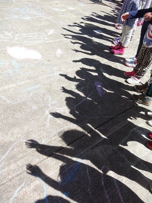 Children's shadows on pavement,