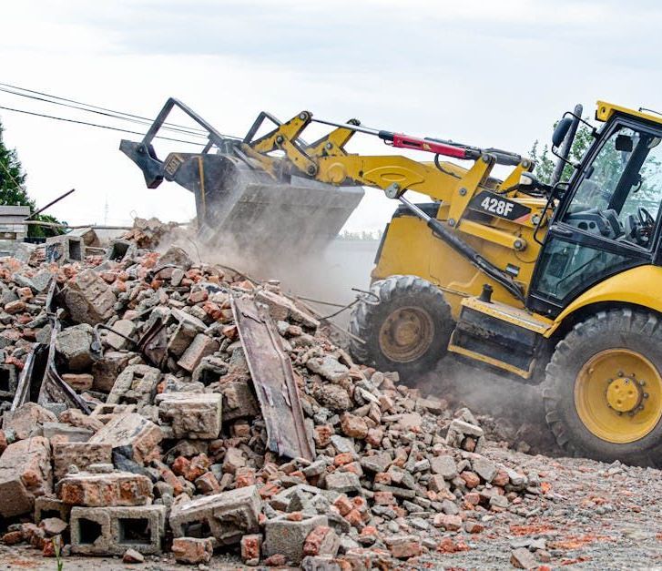 A bulldozer is moving a pile of bricks on a construction site.