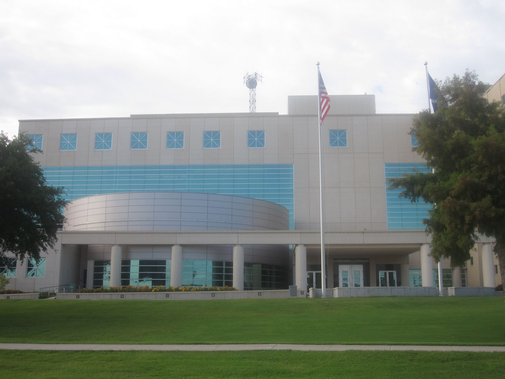 Modern civic building with blue accents, American flag, and grassy lawn in front