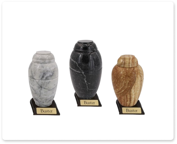 Three decorative urns on stands: gray, black, and gold.