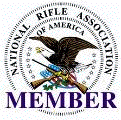 National Rifle Association of America member logo with crossed rifles, eagle seal, and purple “MEMBER” text