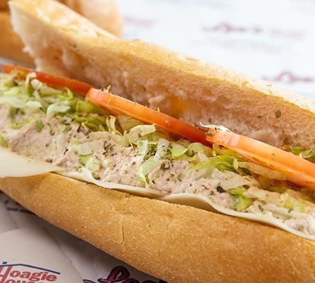 Sandwich with tuna salad, lettuce, and tomato on a toasted baguette