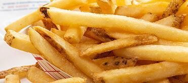 French fries piled on a tray, golden brown and crispy