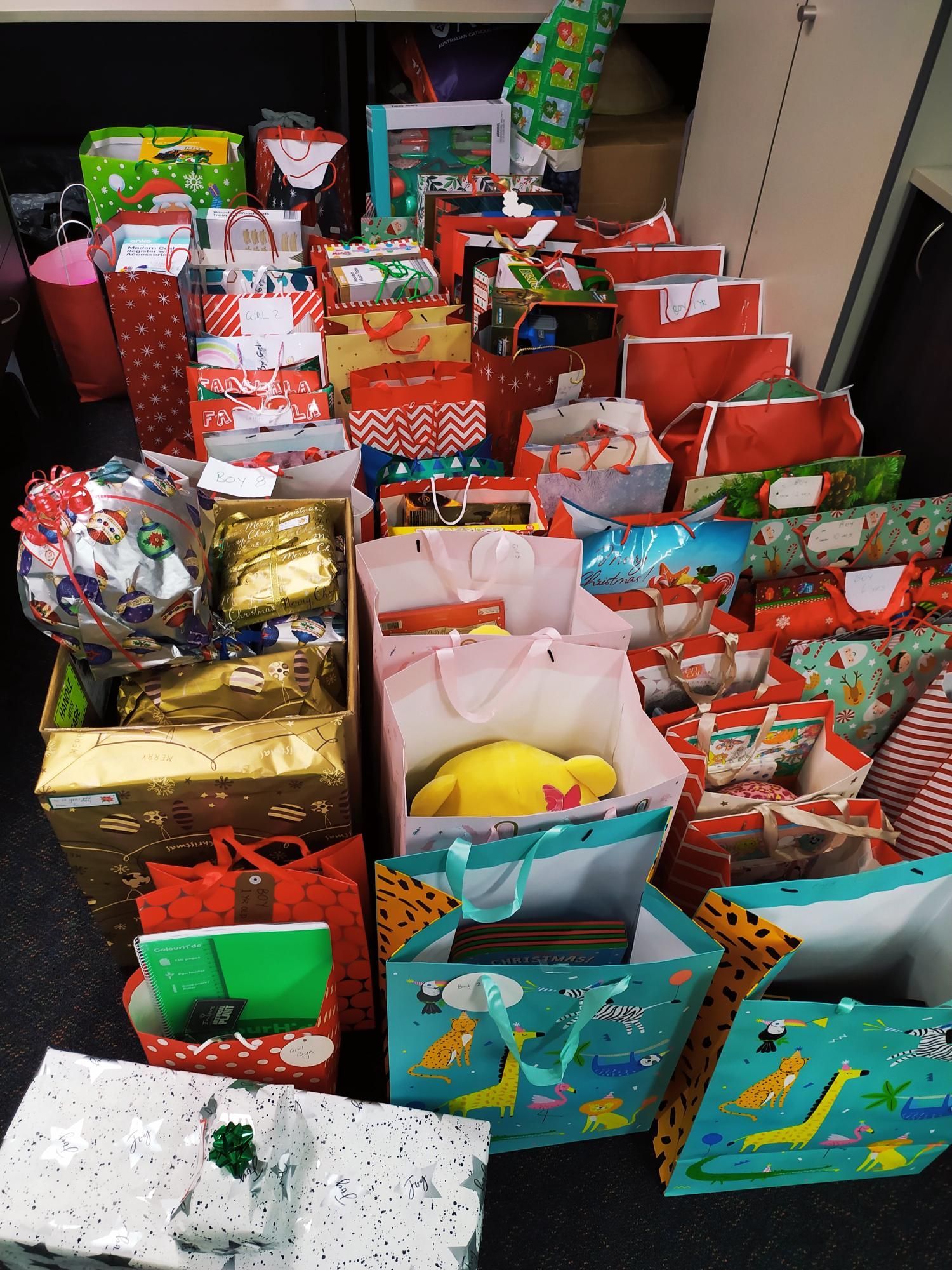 A bunch of christmas presents are stacked on top of each other