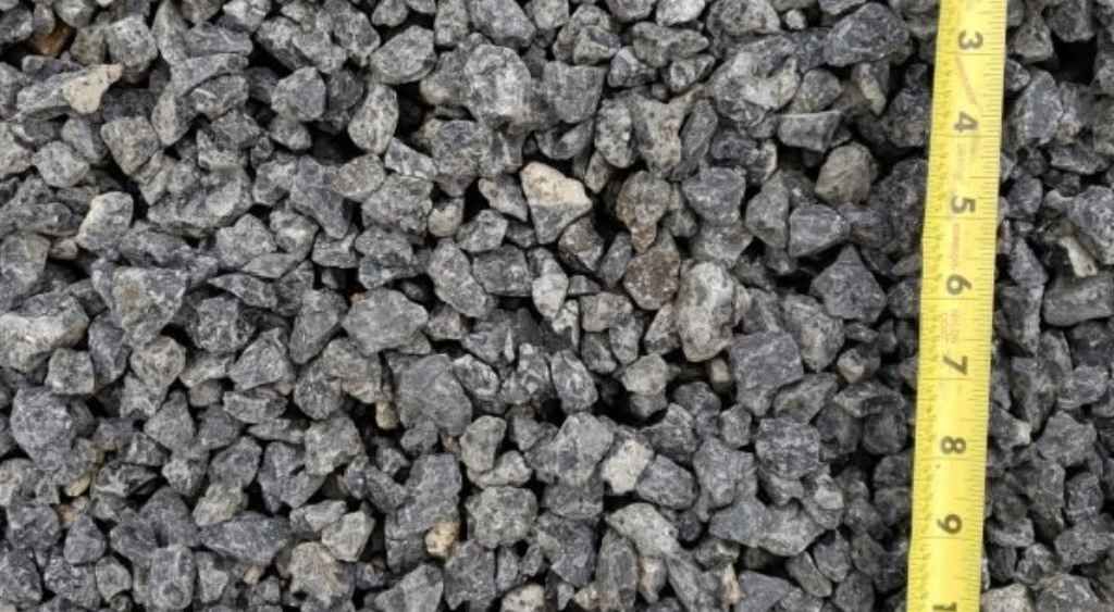 Gray gravel stones with a yellow measuring tape along the right edge