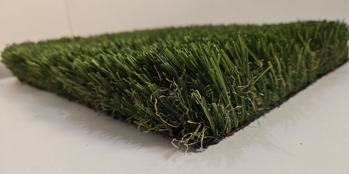 Artificial grass turf sample with dense green blades on a white background