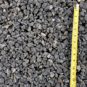 Gray gravel beside a yellow measuring tape showing size scale