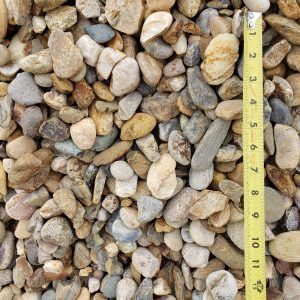 Small tan and gray pebbles beside a yellow measuring tape on the right side.