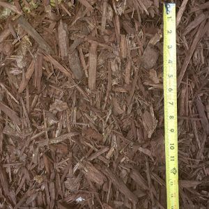 Close-up of brown wood mulch with a yellow measuring tape along the right side.