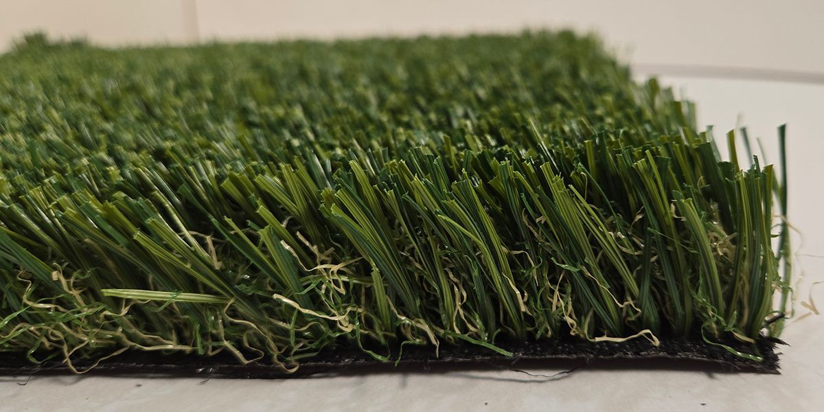 Close-up of green artificial grass turf with dense blades and a black backing