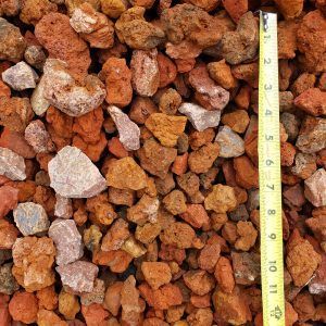 Pile of reddish-brown rocks with a measuring tape along the right edge
