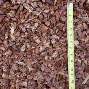 Pile of brown mulch with a measuring tape along the right edge