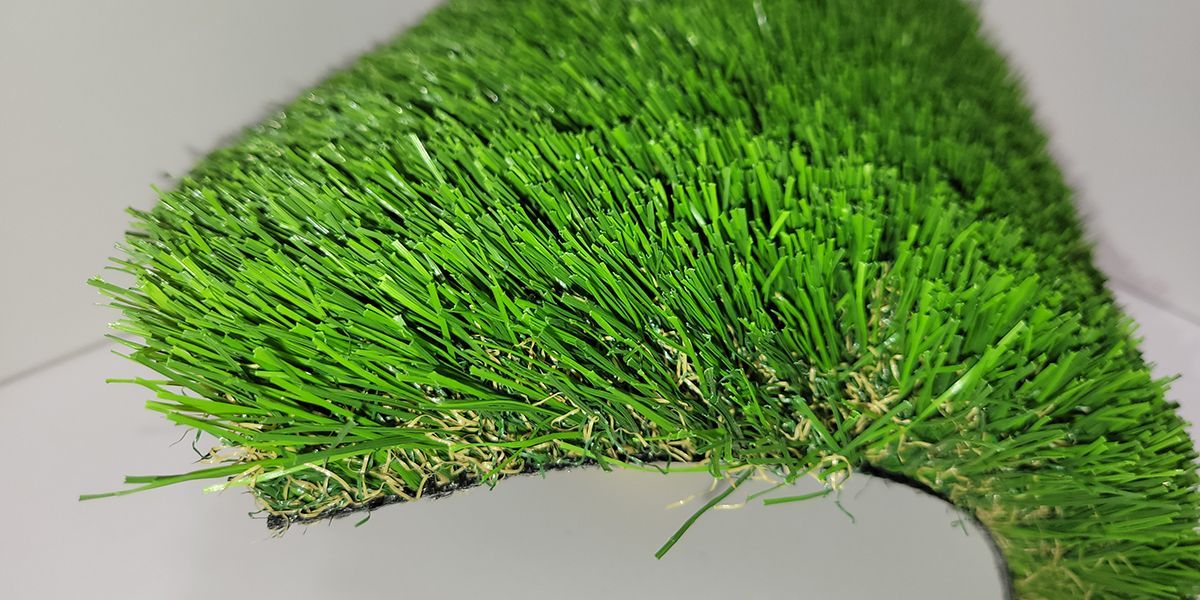 Bright green grass-like patch curving on a light background