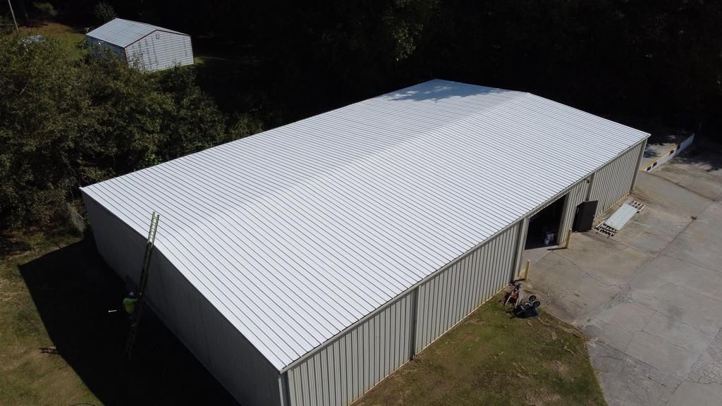 An aerial view of a large white building with a white roof.