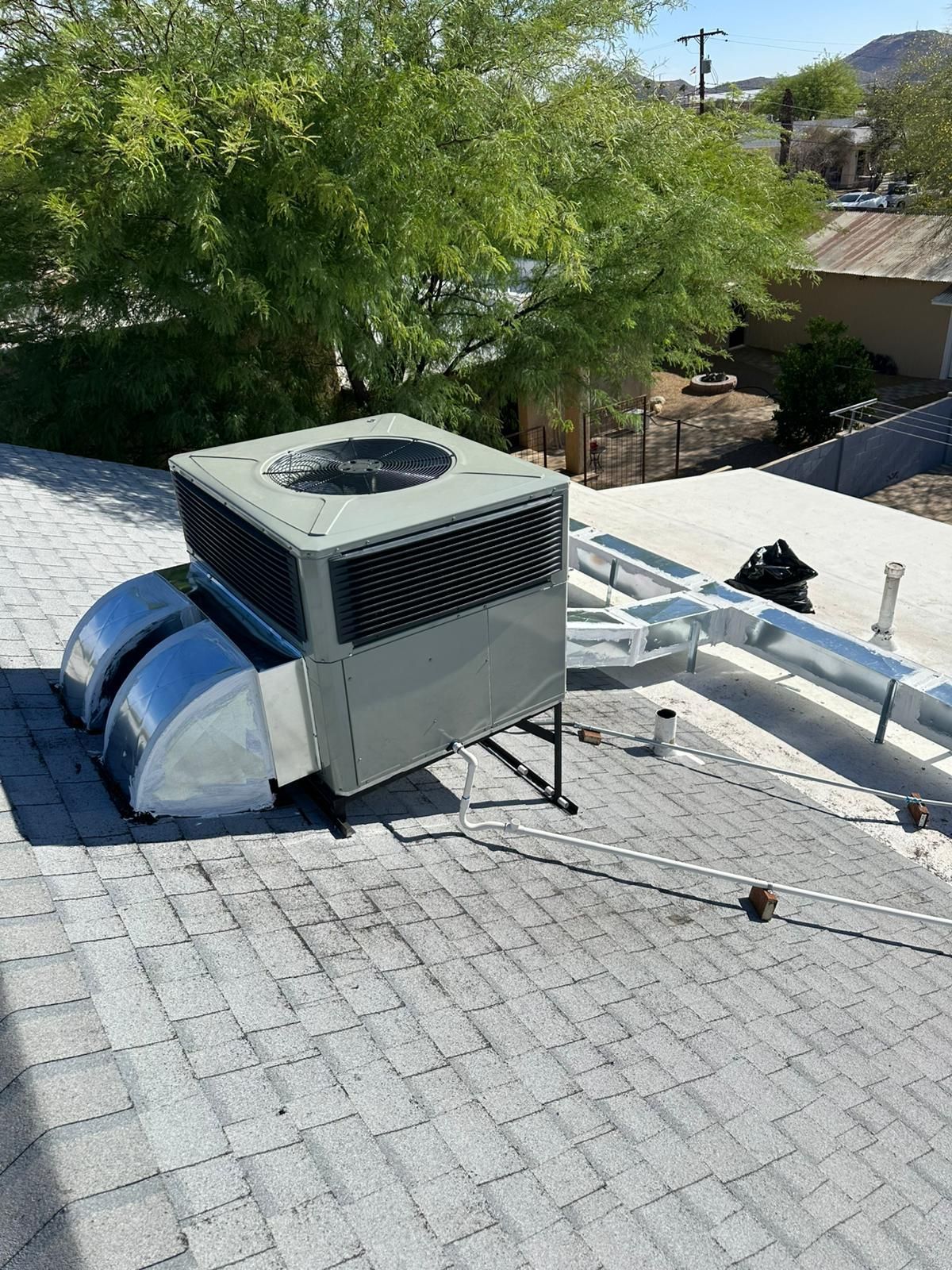 A large air conditioner is sitting on top of a roof.