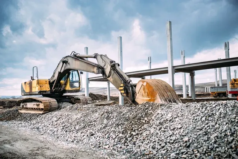 A Yellow Excavator Works on a Gravel Pile at a Construction Site — Copp & Co Civil Plant Hire in Mount Julian, QLD