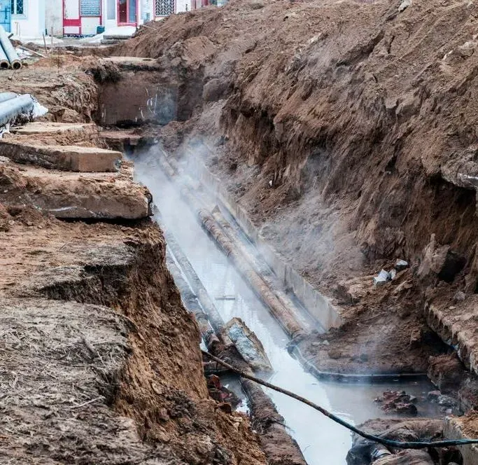 A Deep Trench Cut Into a City Street, Revealing Underground Pipes — Copp & Co Civil Plant Hire in Proserpine, QLD