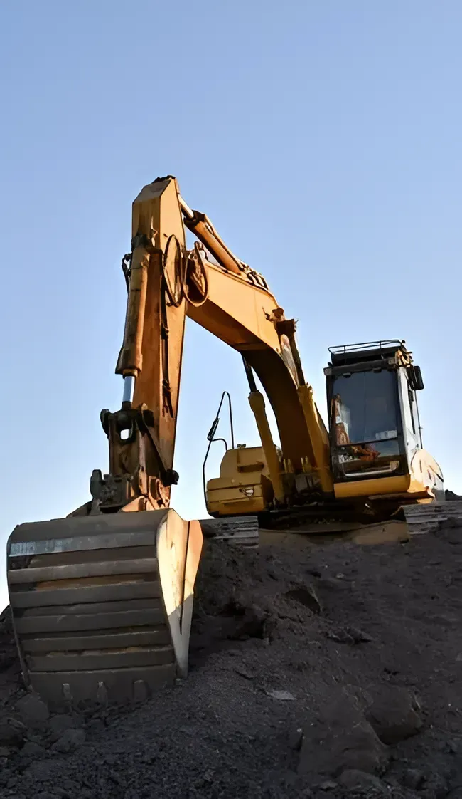 A Yellow Excavator Sits Atop a Mound of Dark, Loose Soil — Copp & Co Civil Plant Hire in Proserpine, QLD